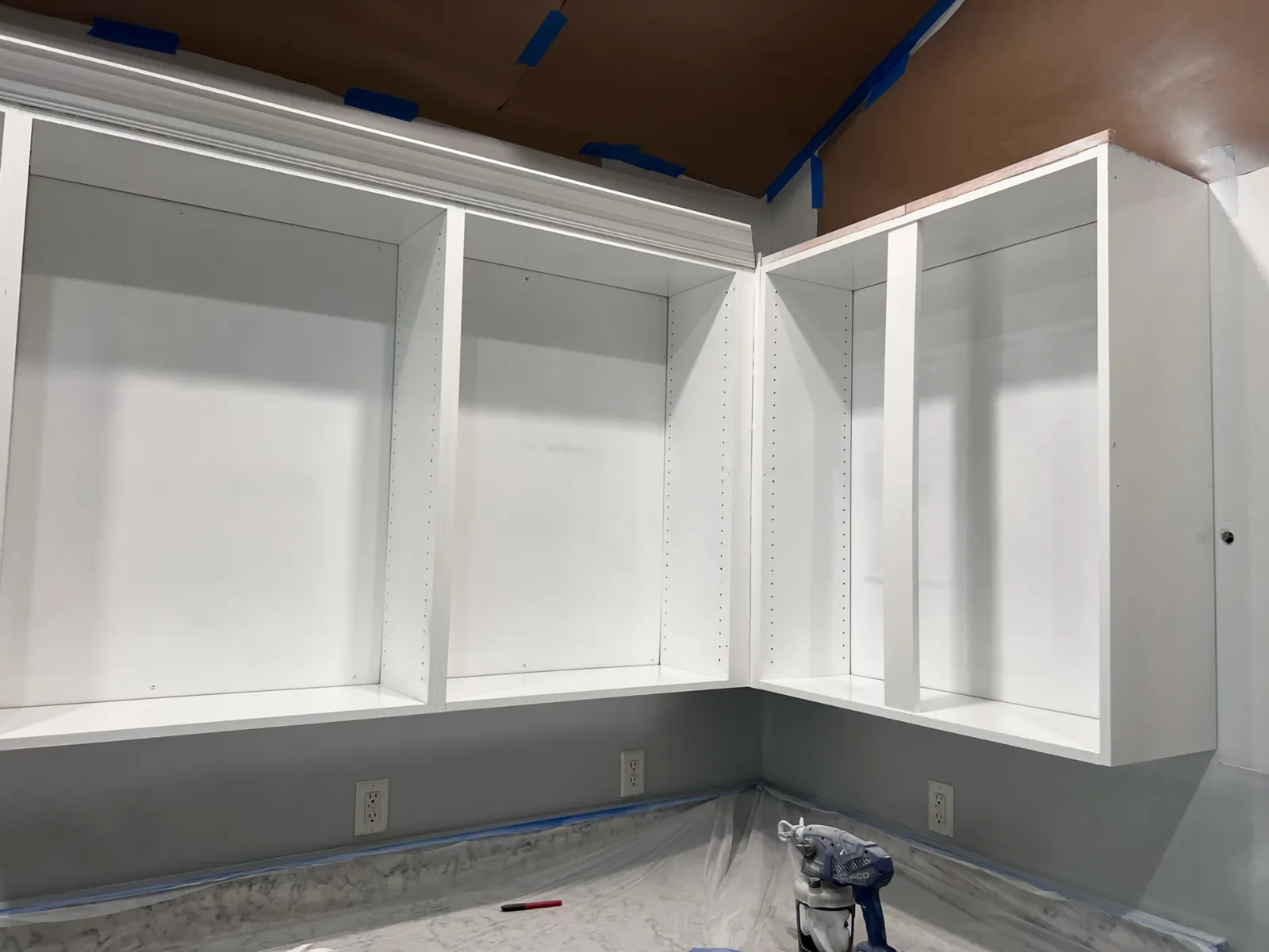 Kitchen cabinet boxes refinished bright white and reinstalled in an L-shaped corner run