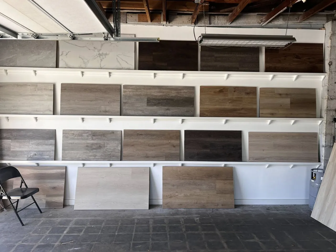 H.E. Douglas flooring showroom wall displaying luxury vinyl, tile, and wood-look samples
