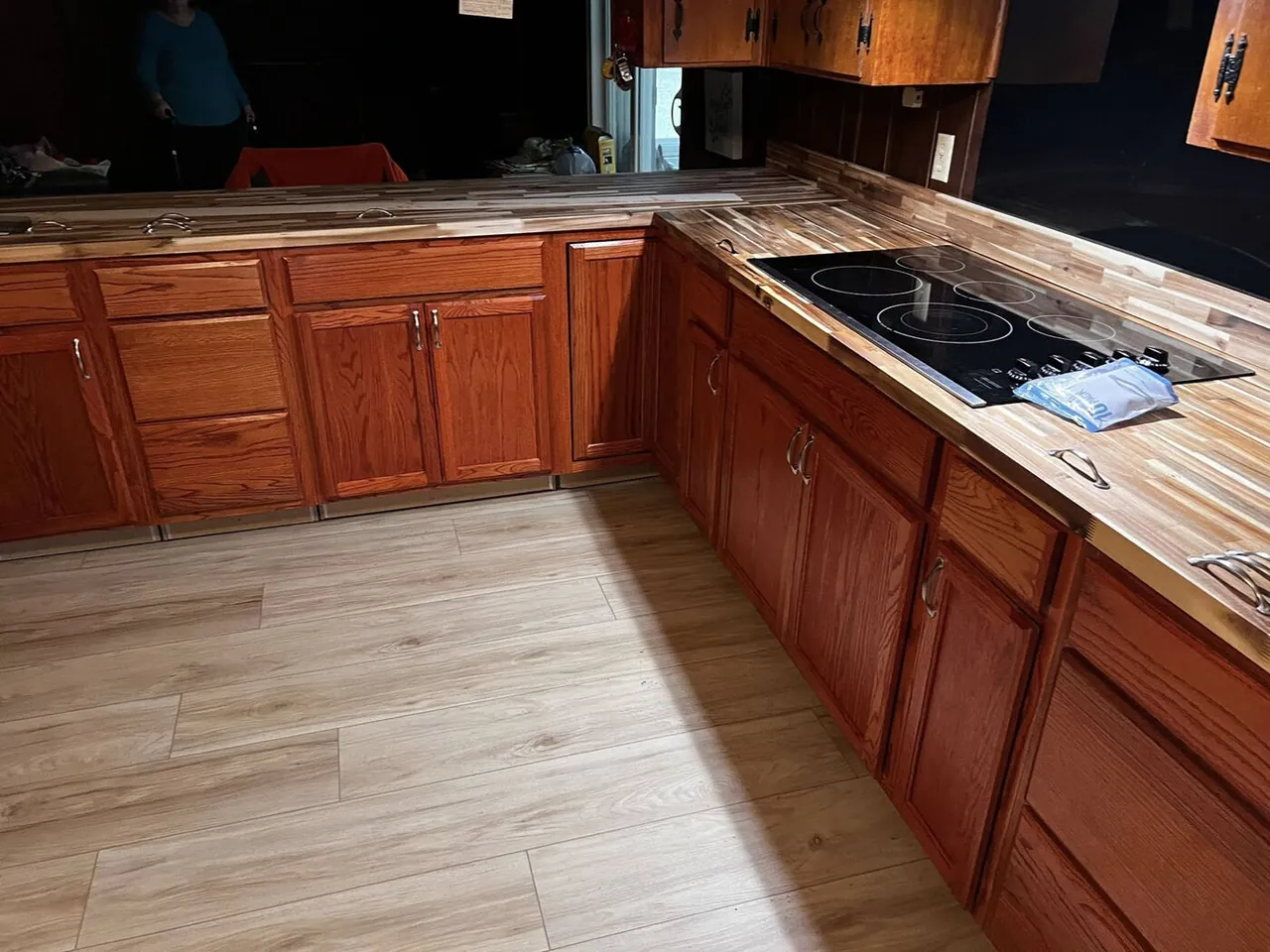 Wood-look tile floor in a kitchen with butcher-block counters and wood cabinets
