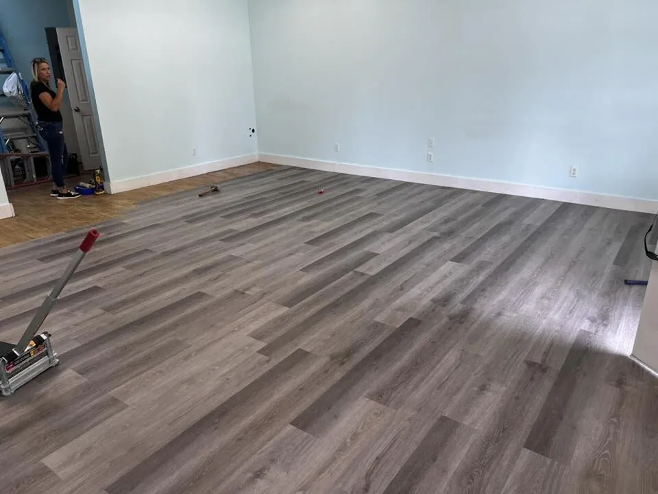 Gray luxury vinyl plank flooring installed across an open living room