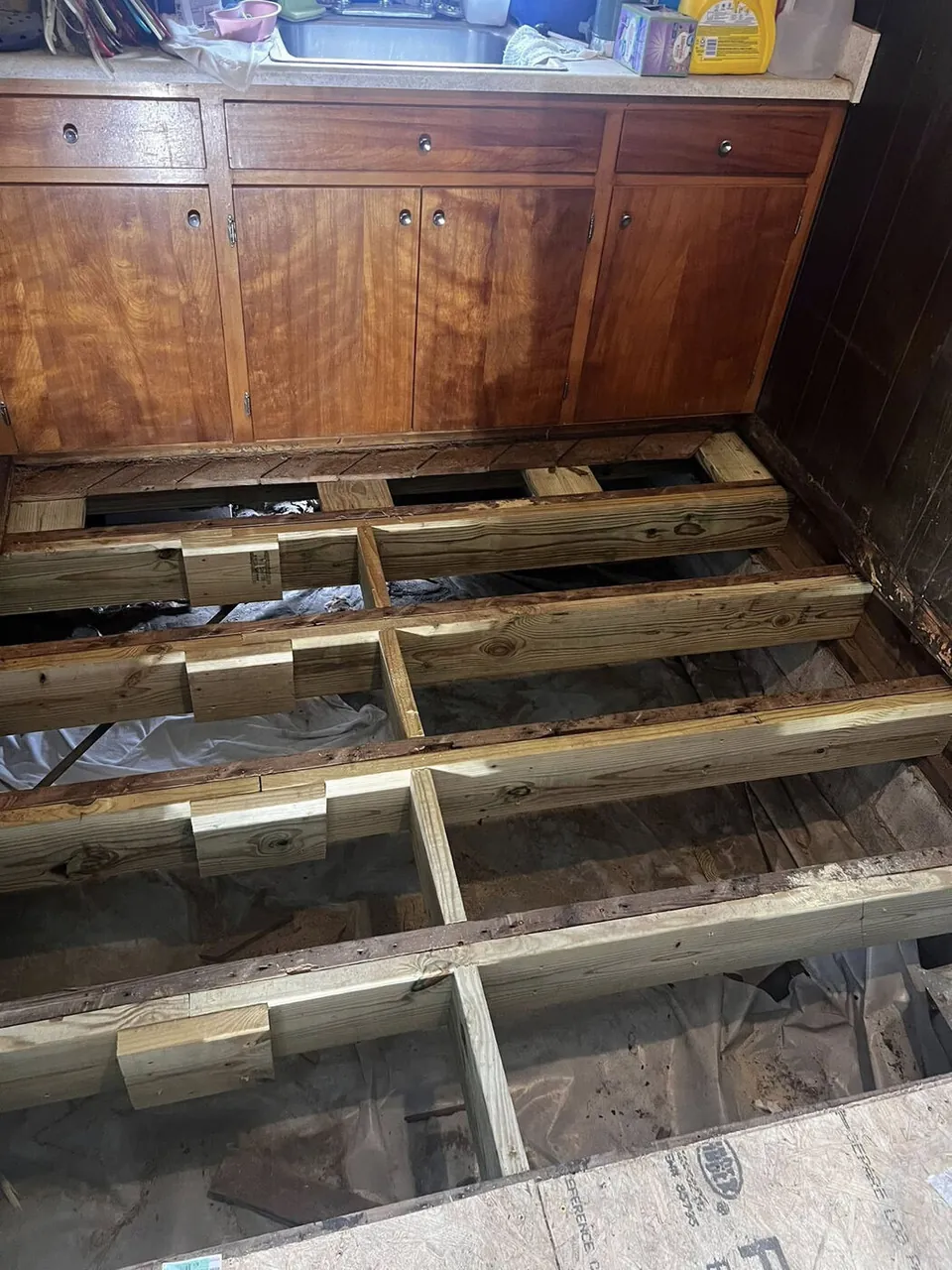 Kitchen floor opened up with new pressure-treated joists sistered in for repair